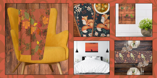 Image shows a cozy throw blanket draped over a chair, a fall themed table runner, a set of autumn fox tea towels and Wall art with fall colors