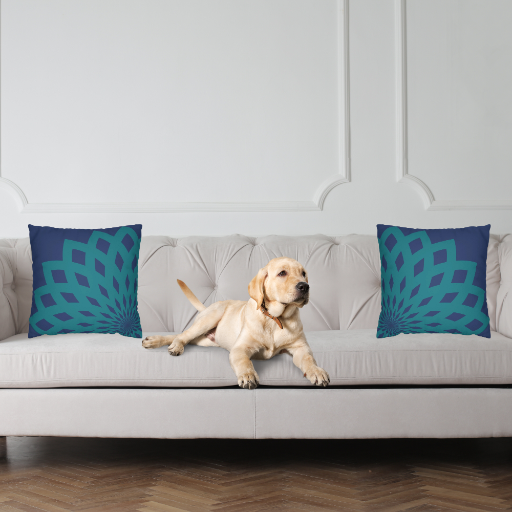 Dark blue throw pillow with large teal floral mandela pattern shown on a couch with a cute dog