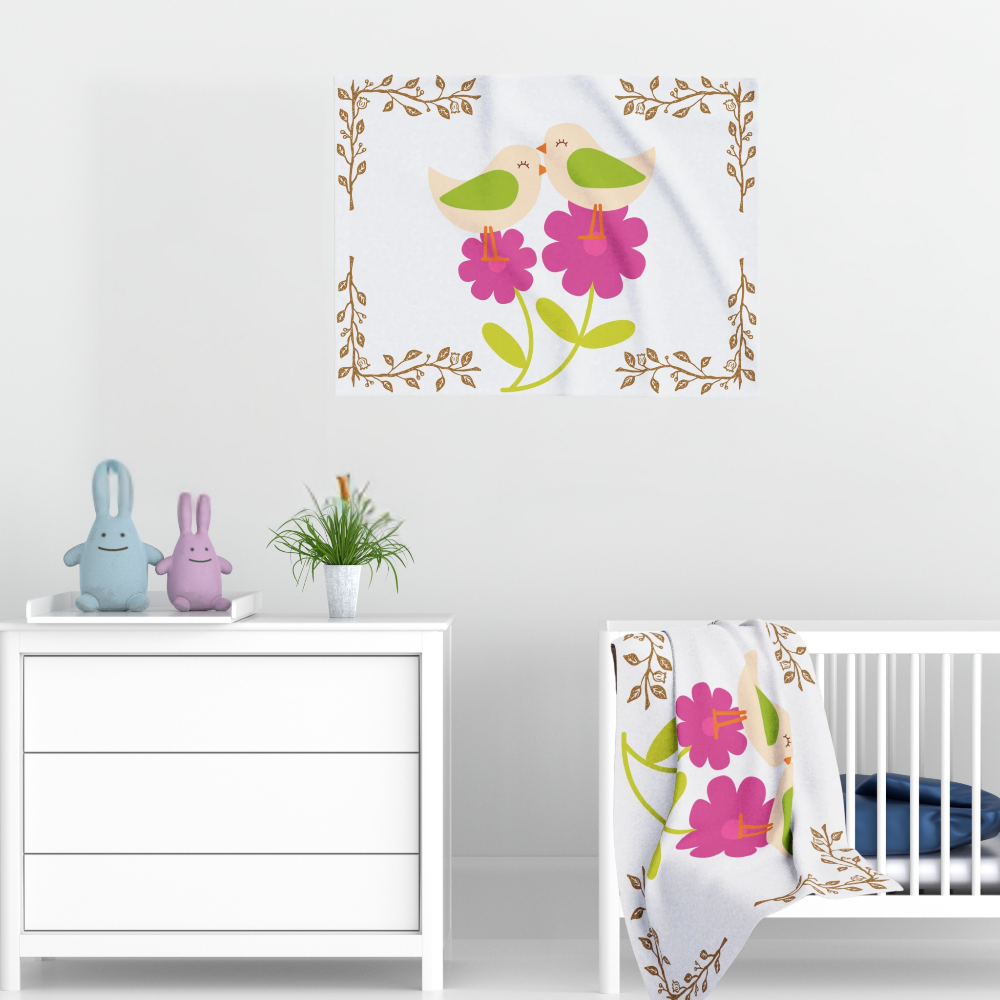 White blanket with bright pink flowers and little birds shown in a nursery setting