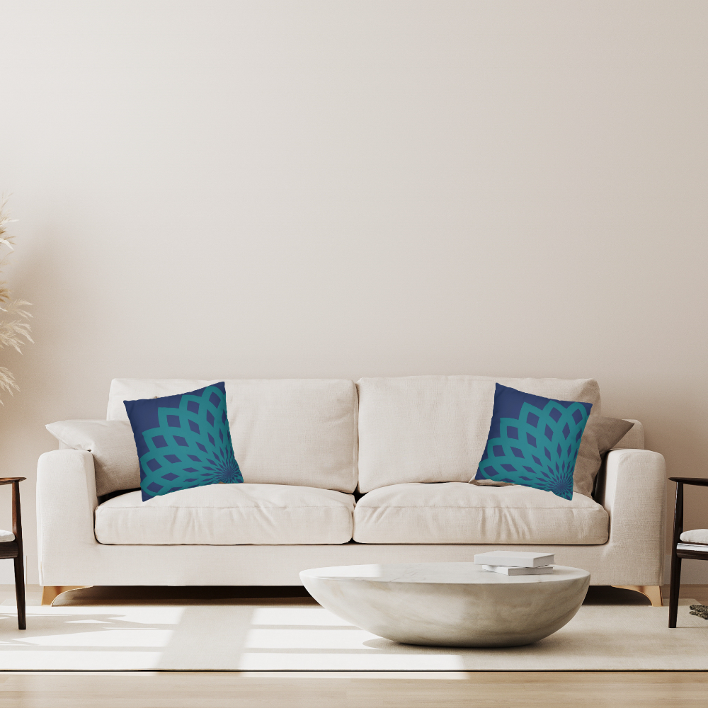 Dark blue throw pillow with large teal floral mandela pattern shown on a white couch