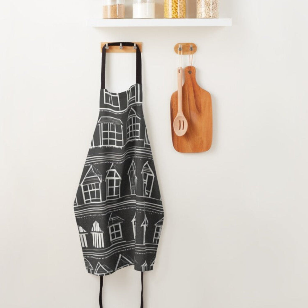 A designer apron with little white houses on a black background