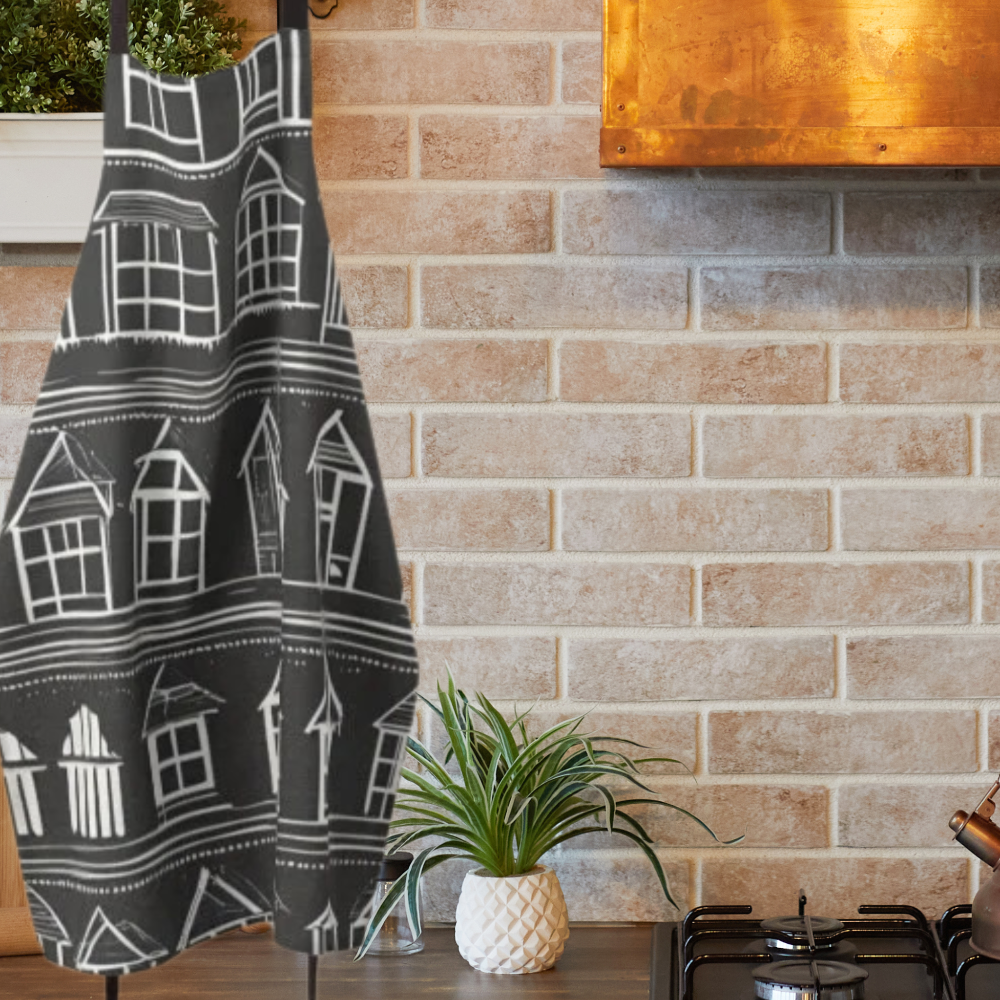 Farmhouse style apron with rows of white houses on a black background shown in a country kitchen