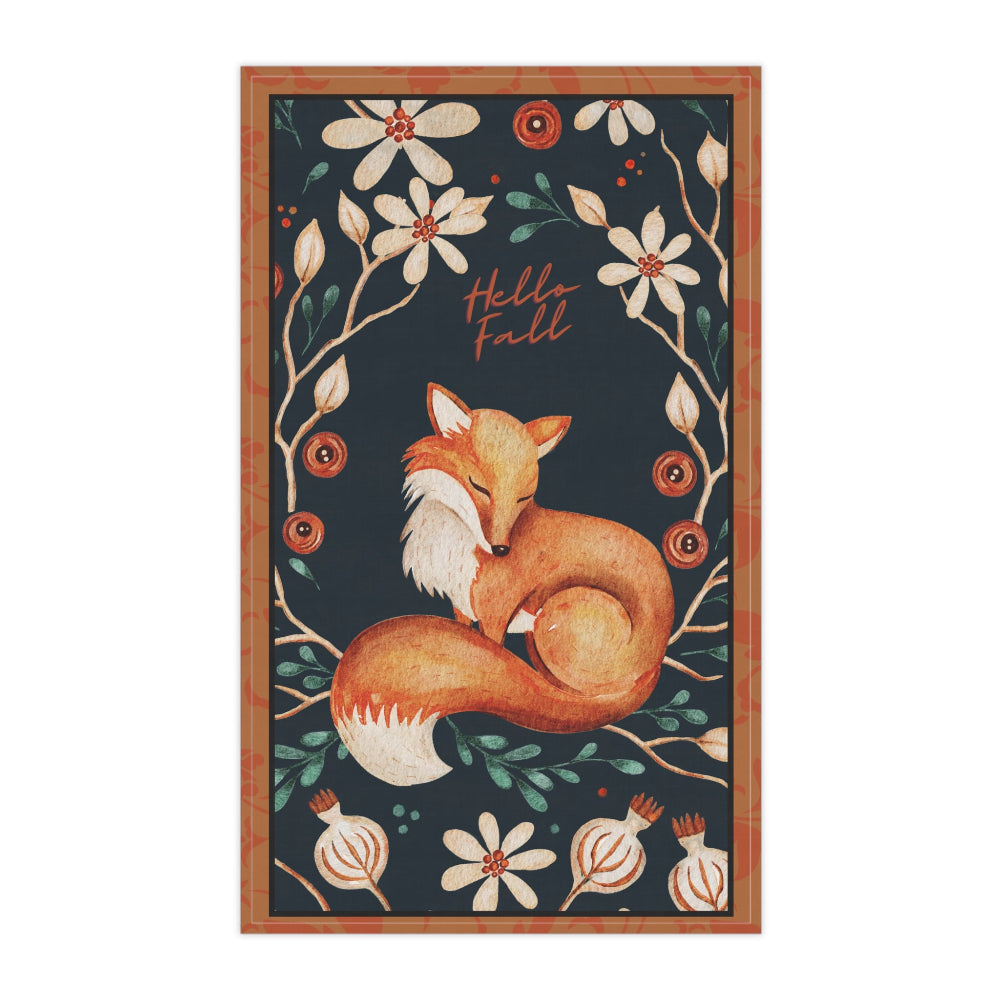 Tea Towel with a fox and floral design on a dark background shown on a white surface