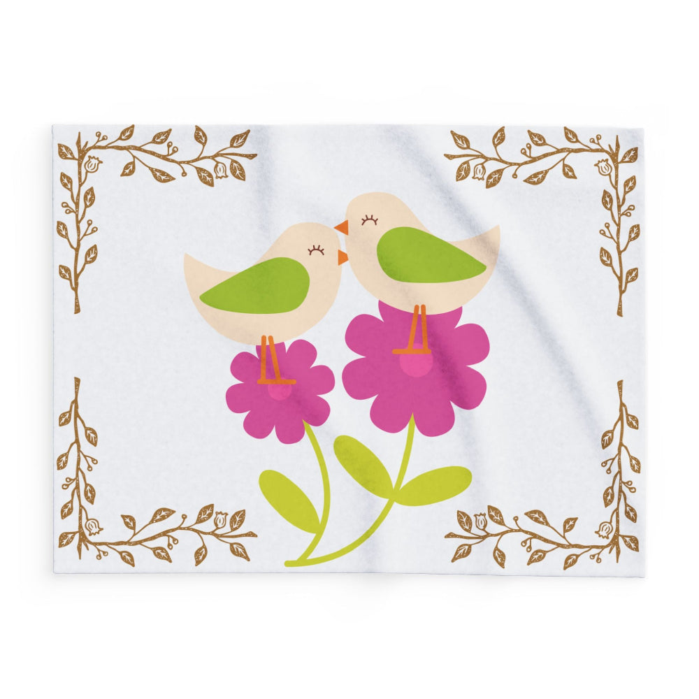 detail of white baby blanket with pink flowers and little birds
