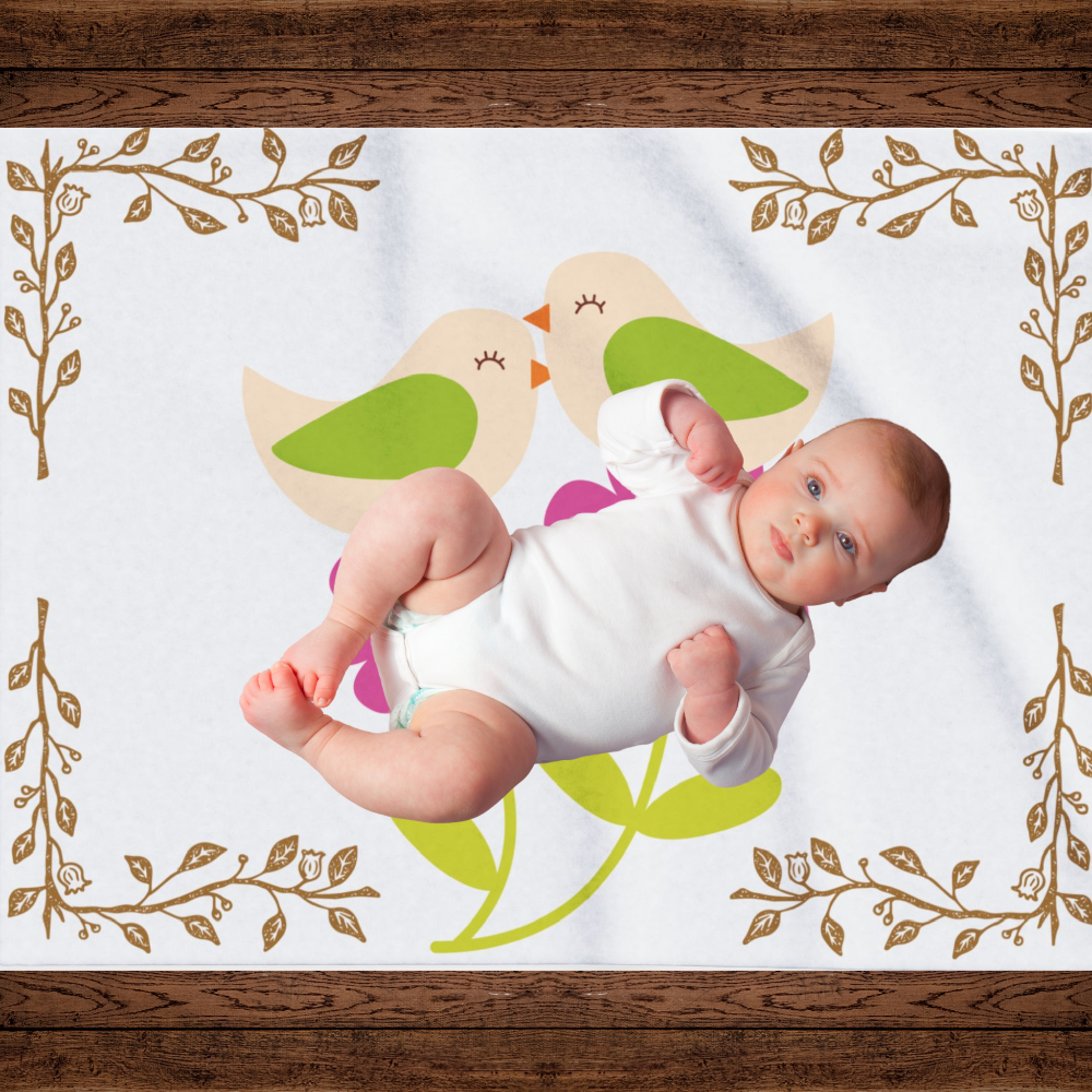 White blanket with bright pink flowers and little birds shown with an infant