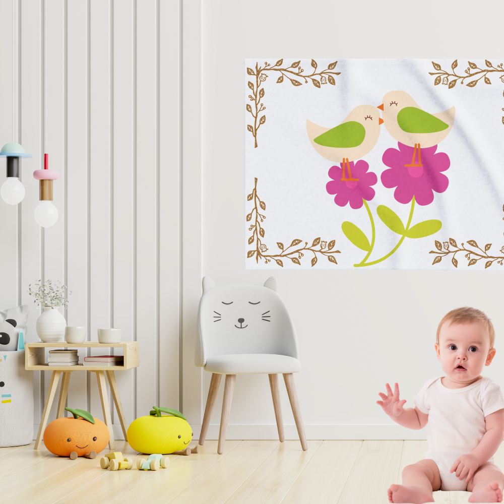 Baby blanket with little birds on pink flowers hung on a wall in a nursery with a cute baby in front