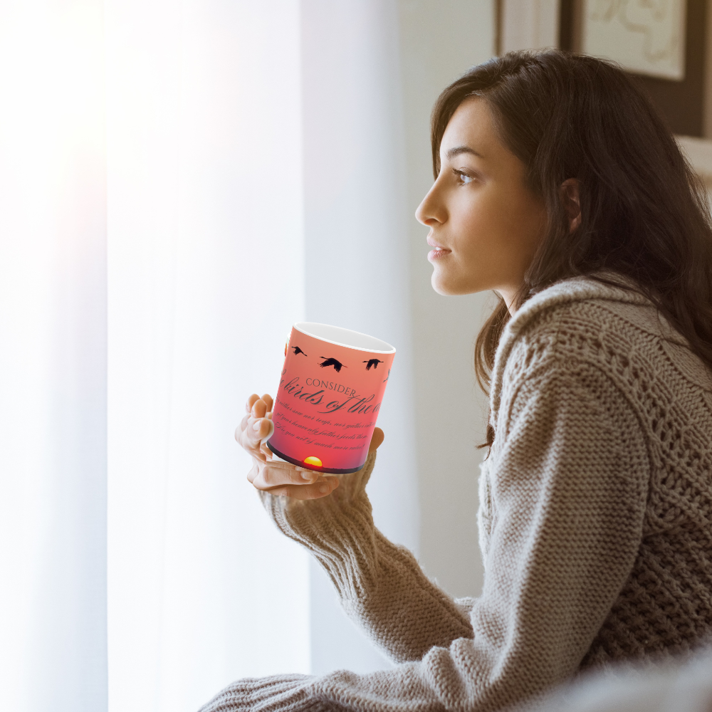Consider the birds inspirational ceramic mug shown with a woman holding it while looking out the window