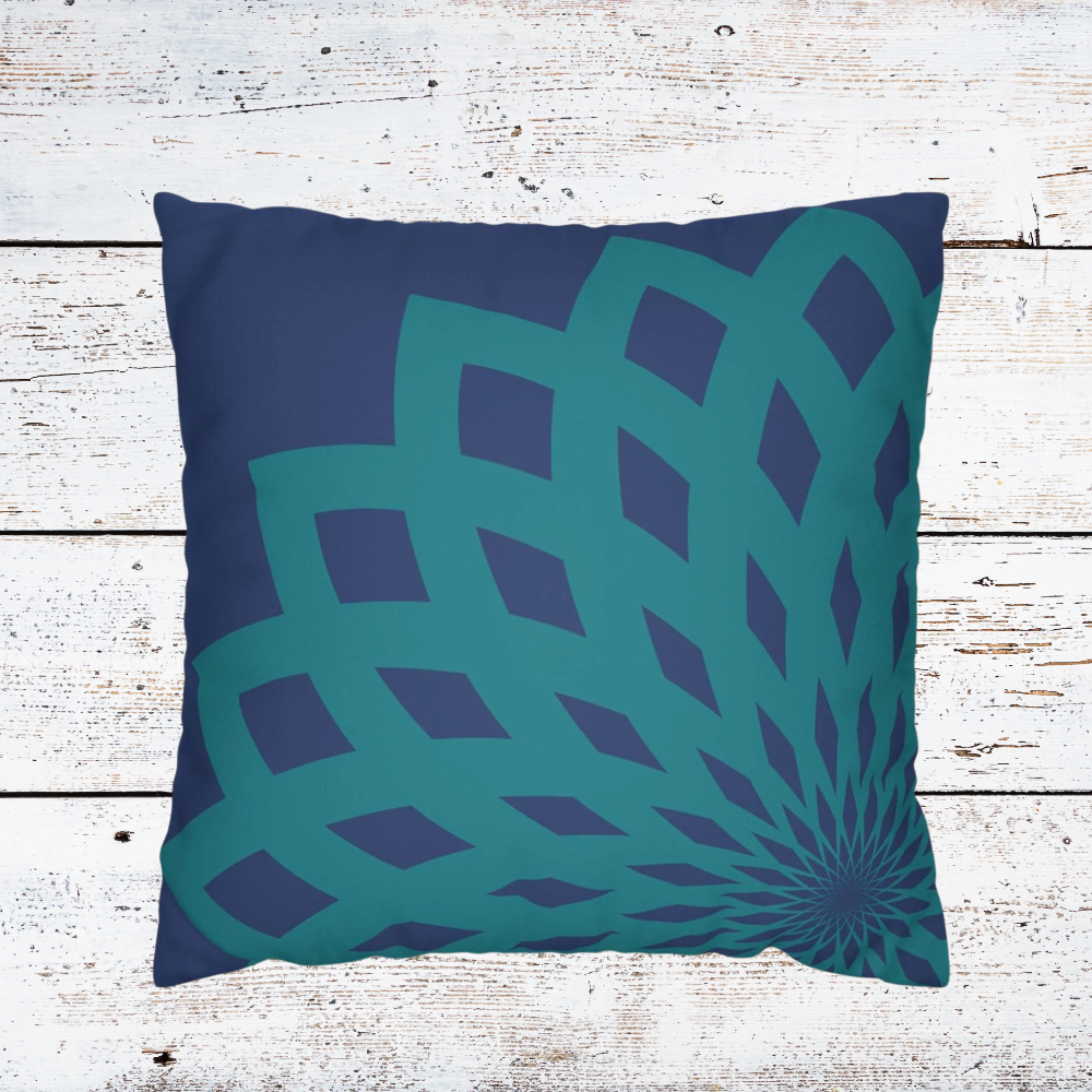 Detail of dark blue pillow with teal mandela print shown on a white wood background