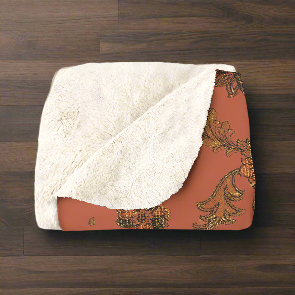 Blanket with white sherpa interior and floral patterned border on a white background