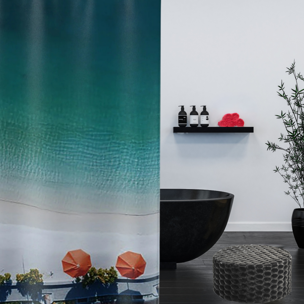 An ombre blue shower curtain with bright orange umbrellas  shown with a black tub in a luxe bathroom
