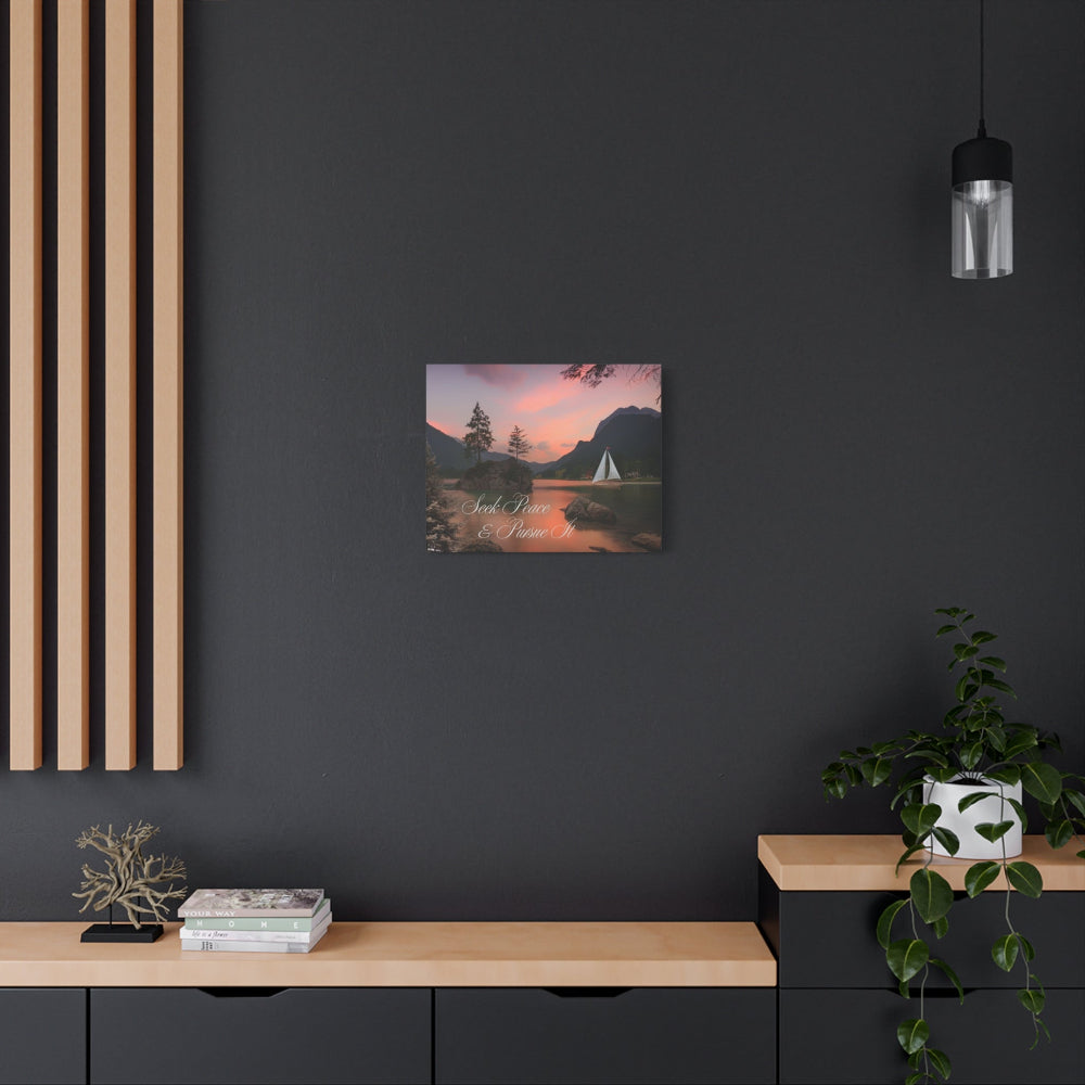 Art print of a mountain landscape with a sailboat on a dark wall above a wooden shelf.