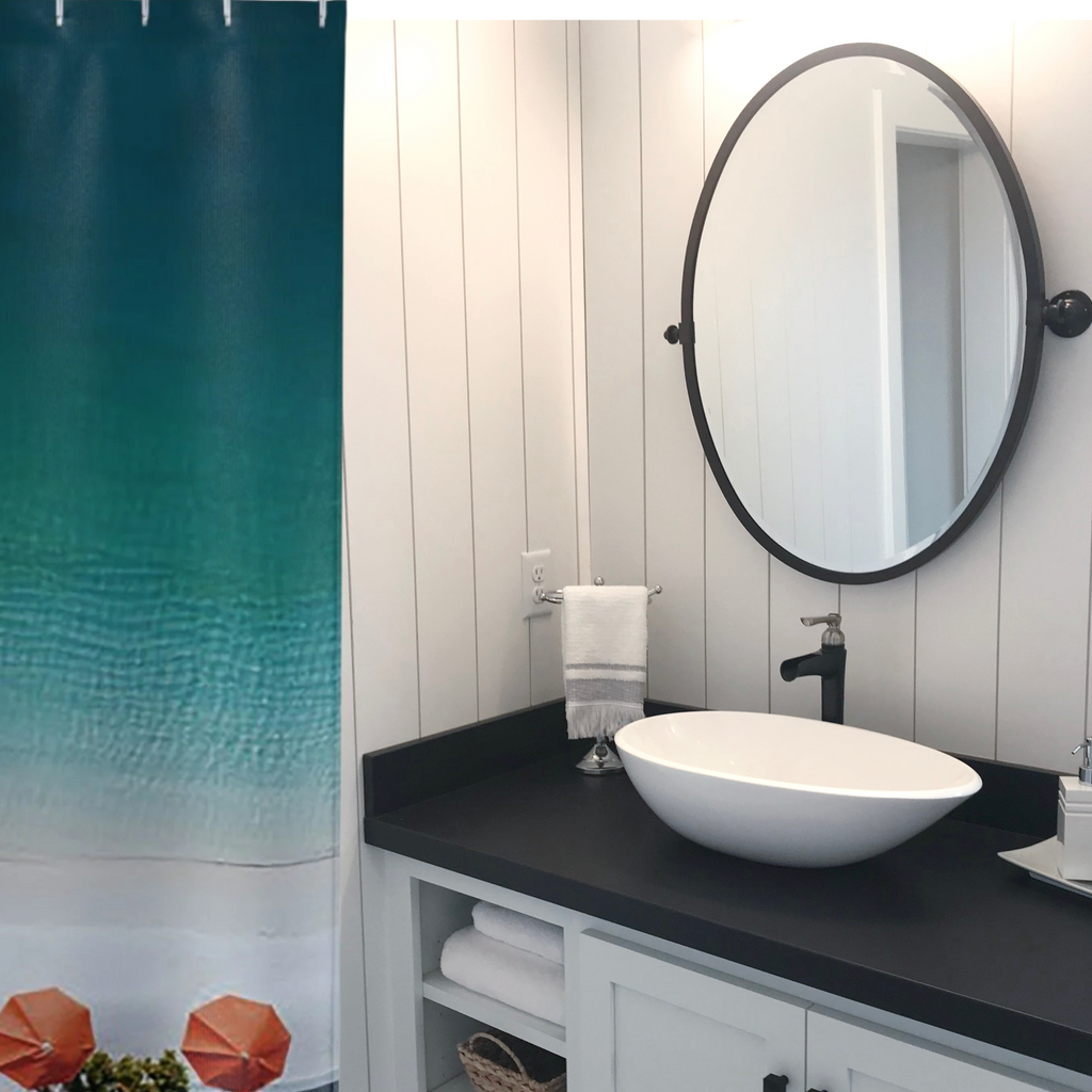 A beautiful blue ombre shower curtain with orange beach umbrellas shown in a black and white bathroom