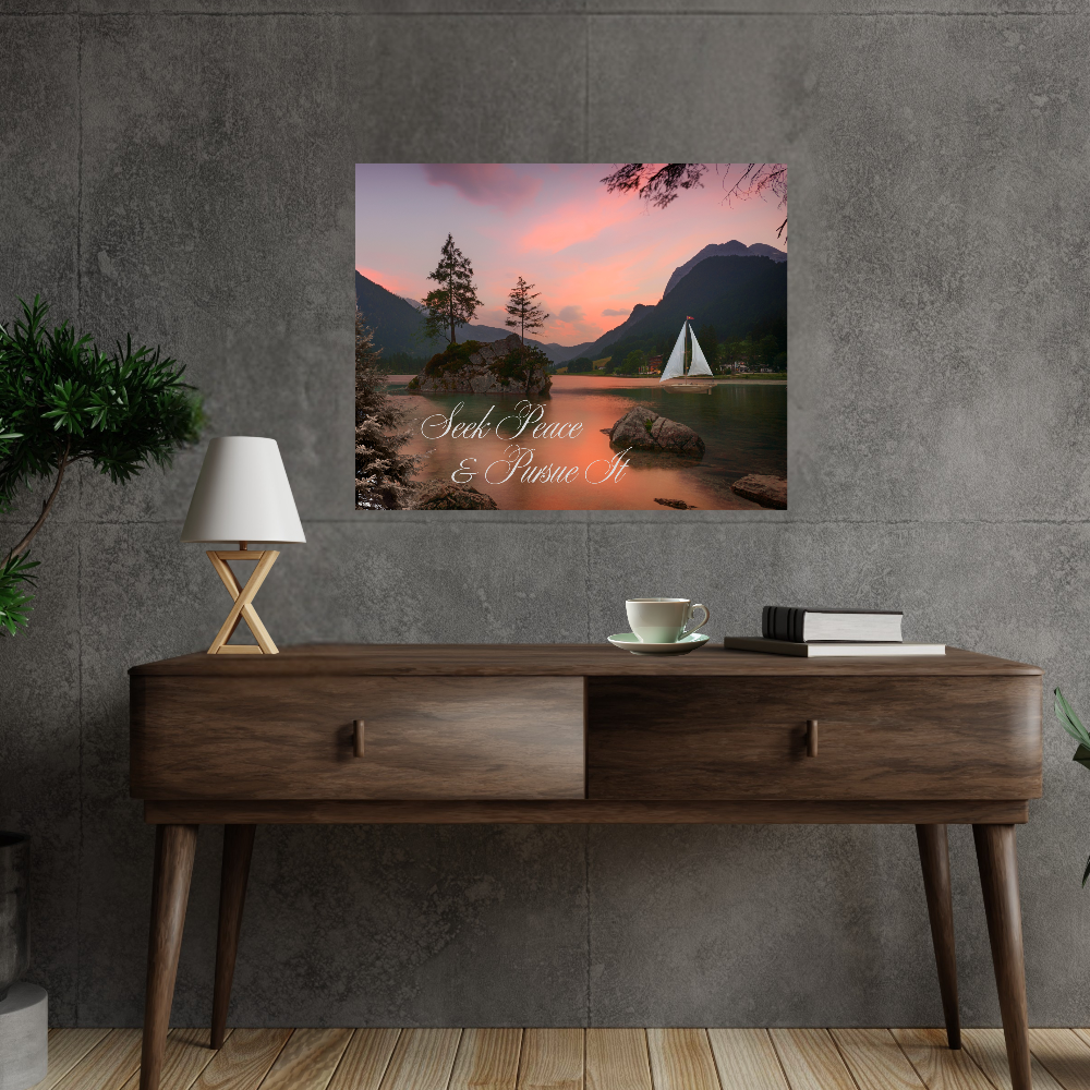 Canvas wall art of a sailboat on water with mountains and trees, with the saying Seek Peace and Pursue It displayed above a wooden desk.