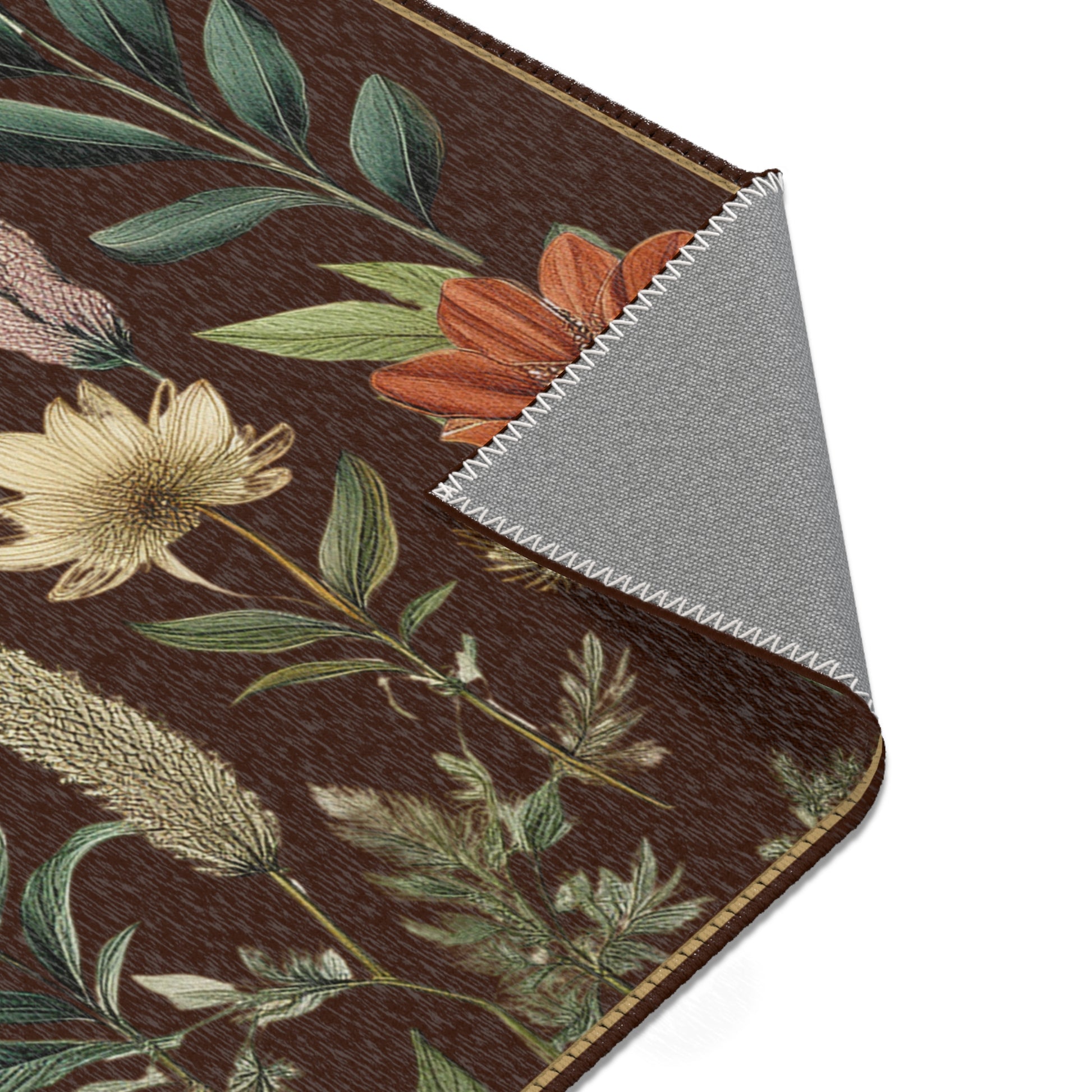 Close-up of floral-patterned rug with a contrasting gray backing underneath.