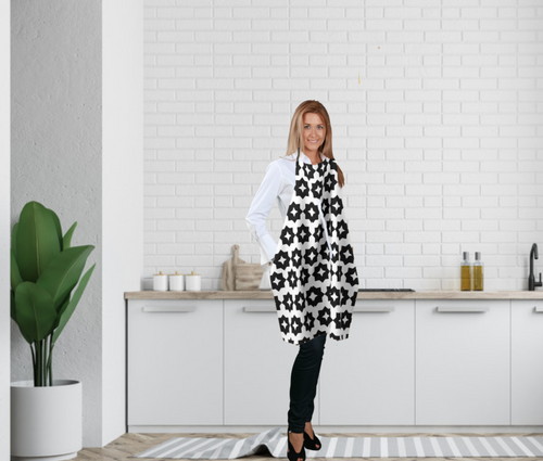 Photo features a  woman standing in a kitchen wearing a black and white farmhouse style graphic