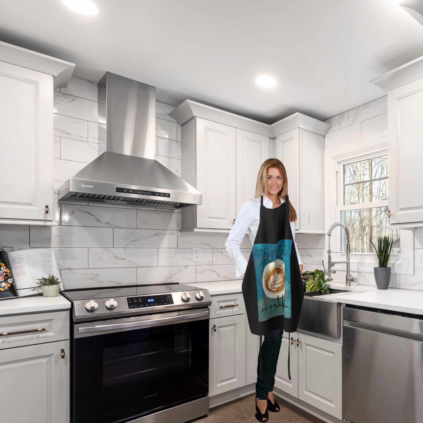 woman standing in kitchen wearing a black apron with a decorative cup of coffee
