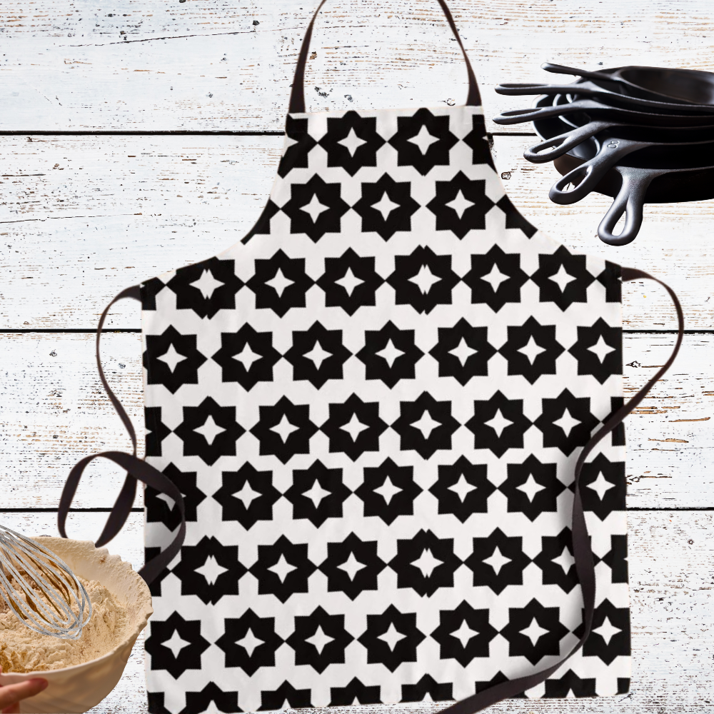 Black and white geometric apron shown with kitchen utensils