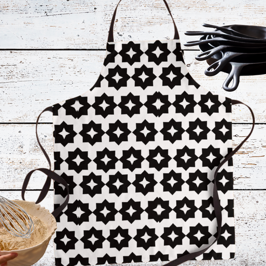 Black and white geometric apron shown with kitchen utensils