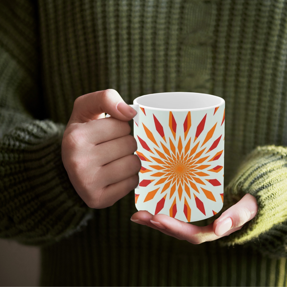 orange starburst mug shown with a woman in a green sweater holding it