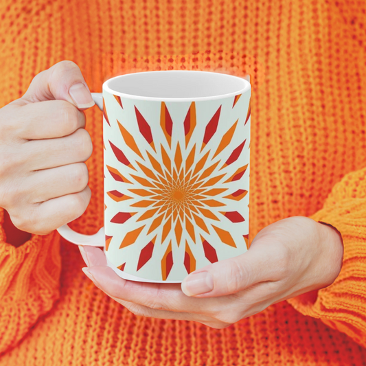orange starburst mug shown with a woman in an orange sweater holding it