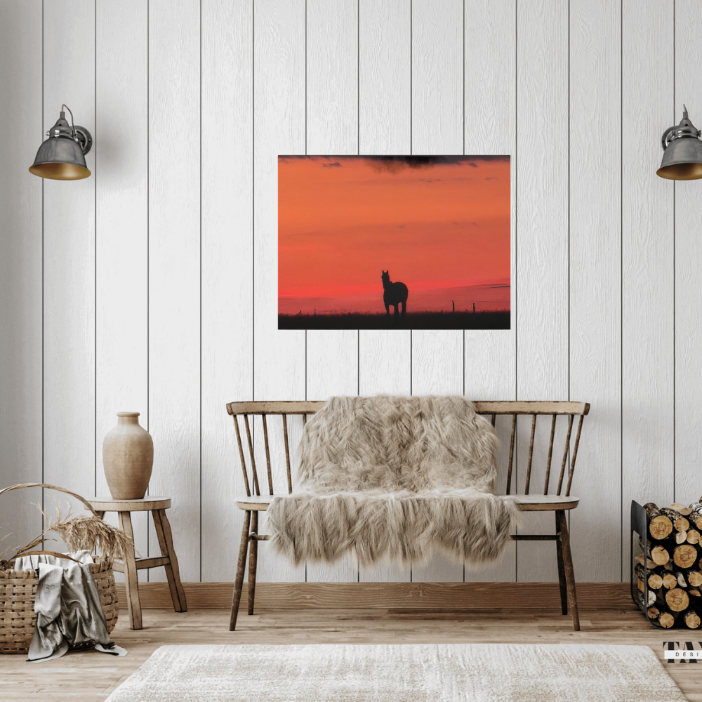 Silhouette of a horse at sunset shown in a farmhouse style setting with a wooden bench, firewood and accessories.