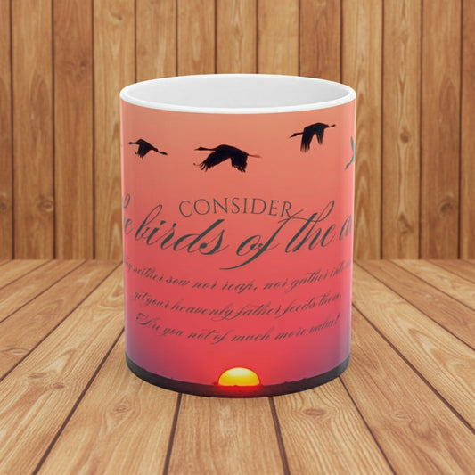 Ceramic Mug with sunset design and ducks flying with bible verse consider the birds shown on a wood background