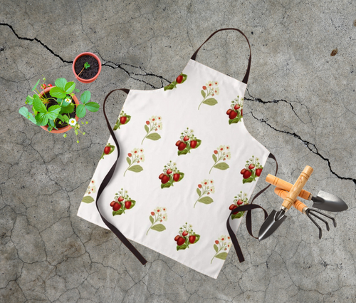 Vintage inspired strawberry print apron shown with garden tools 
