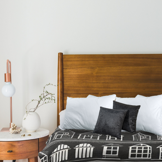 Home Sweet Home Comforter shown  in a cozy bedroom setting with a round wooden table 