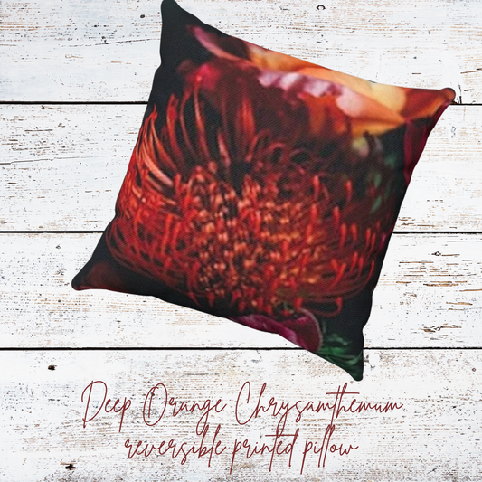 Floral throw pillow with deep orange chrysanthemum print on white wood background.