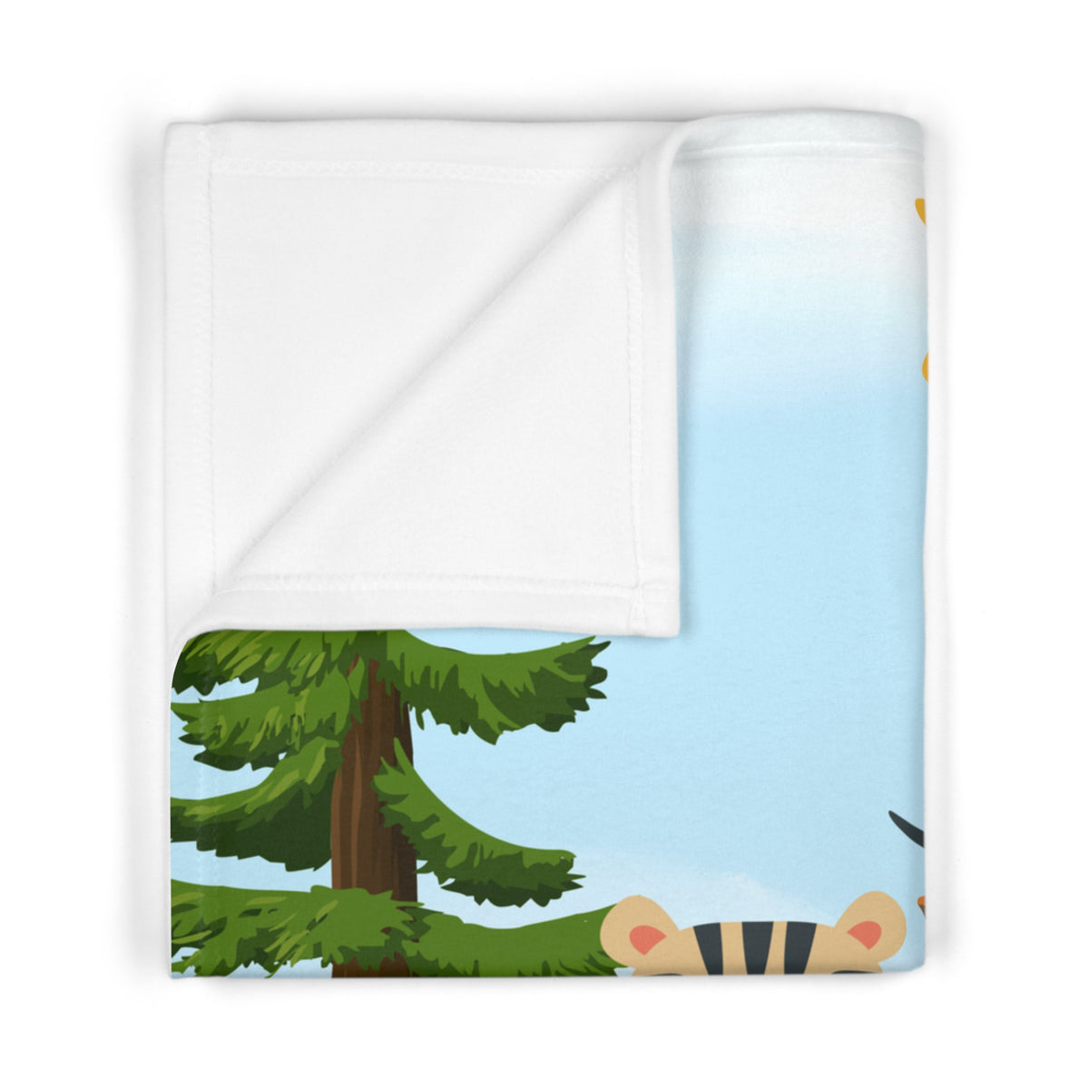 A folded white blanket with a printed cartoon forest design, showing green pine trees, a light blue sky, and a peek of a tiger on the edge, photographed on a white background.