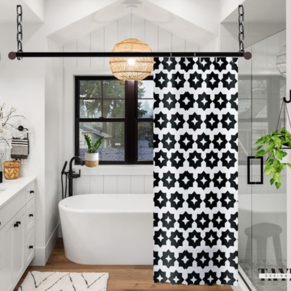 A black and white geometric patterned shower curtain shown in an elegant bathroom