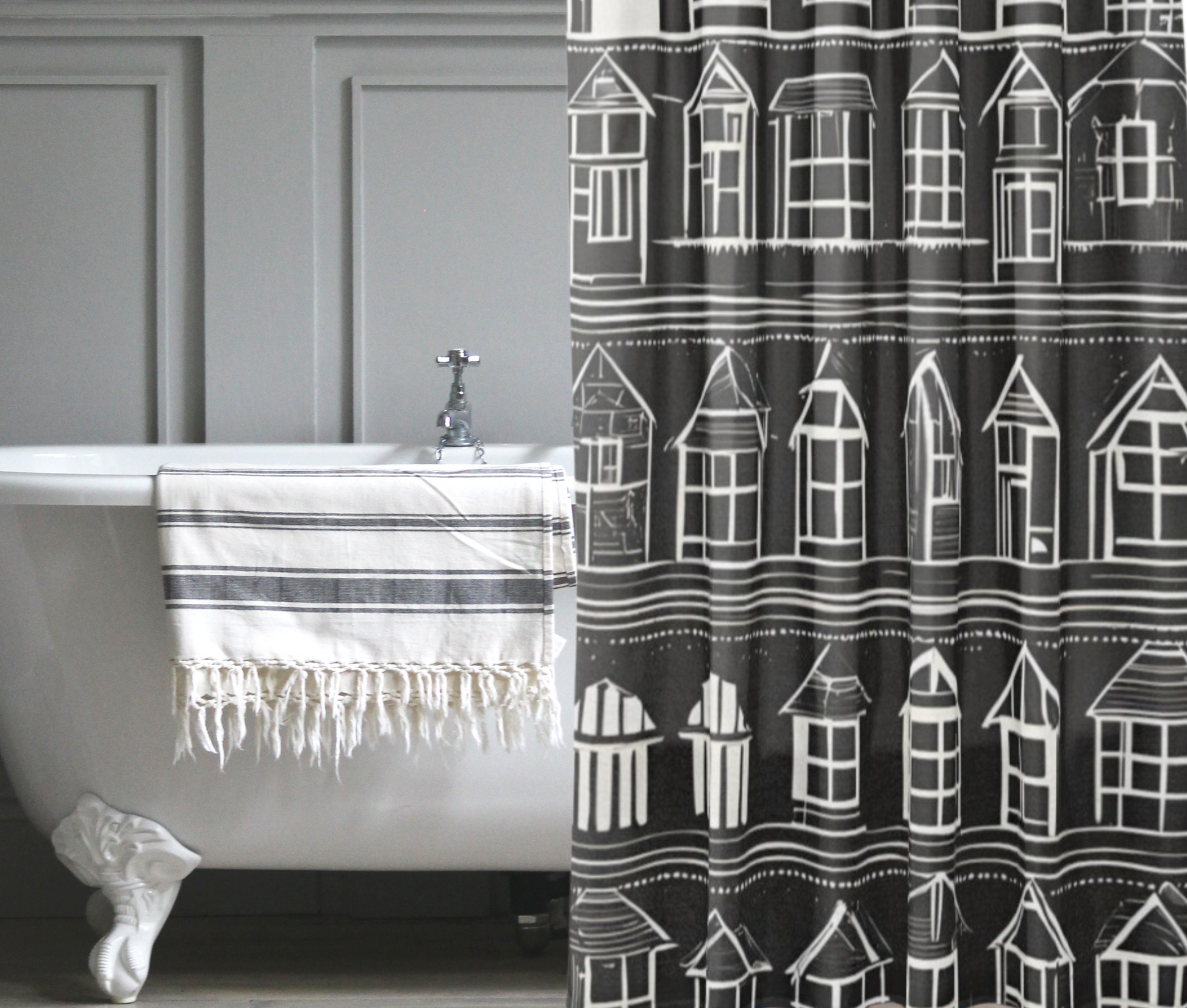 A beautiful black shower curtain with rows of white houses shown in a nostalgic bath setting.