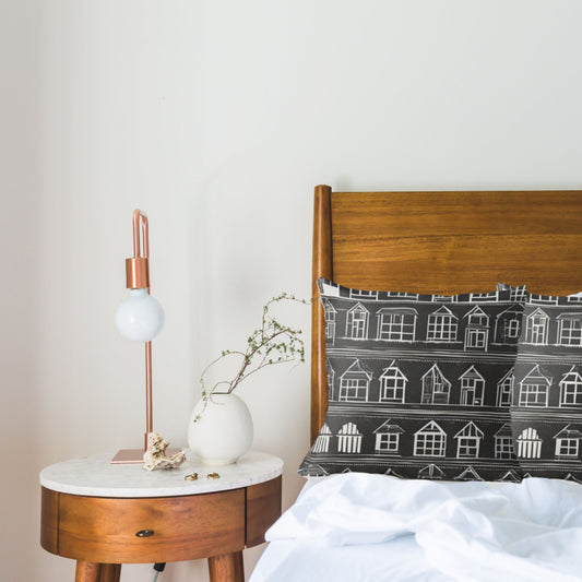 home sweet home pillow shown in a bedroom with a wooden headboard and side table