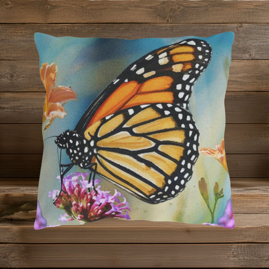 Closeup of design featuring a large, vibrant orange, gold and black butterfly on a watercolor blue background with orange and lavender colored flowers.