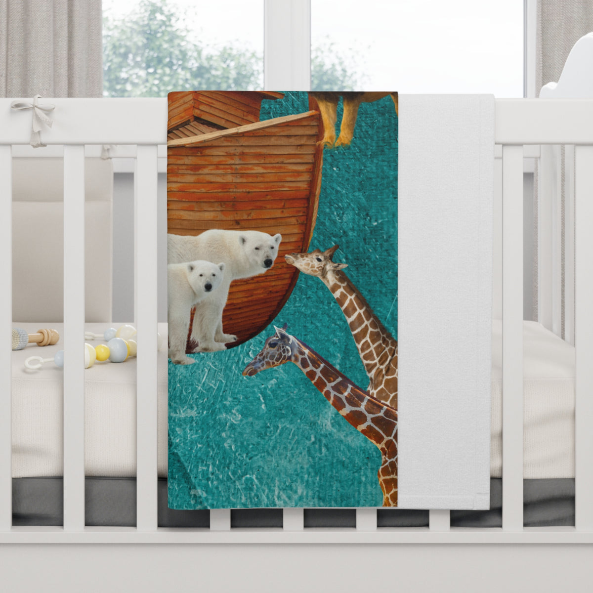A white baby crib with a printed fleece blanket draped over the side, showing polar bears and giraffes beside a wooden boat on a teal background. The full image is of Noahs Ark
