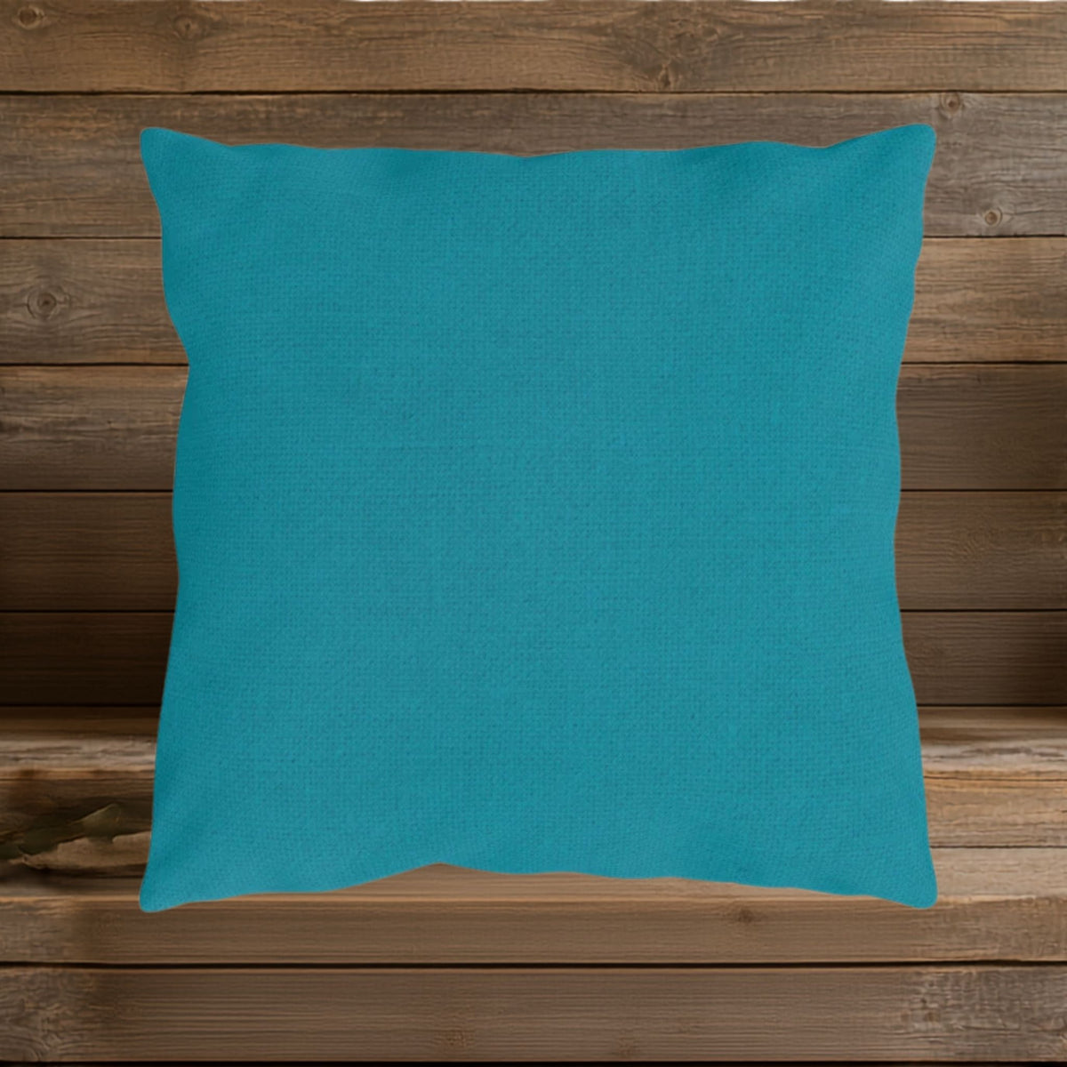 Light teal linen-look  indoor outdoor pillow shown on a wood background