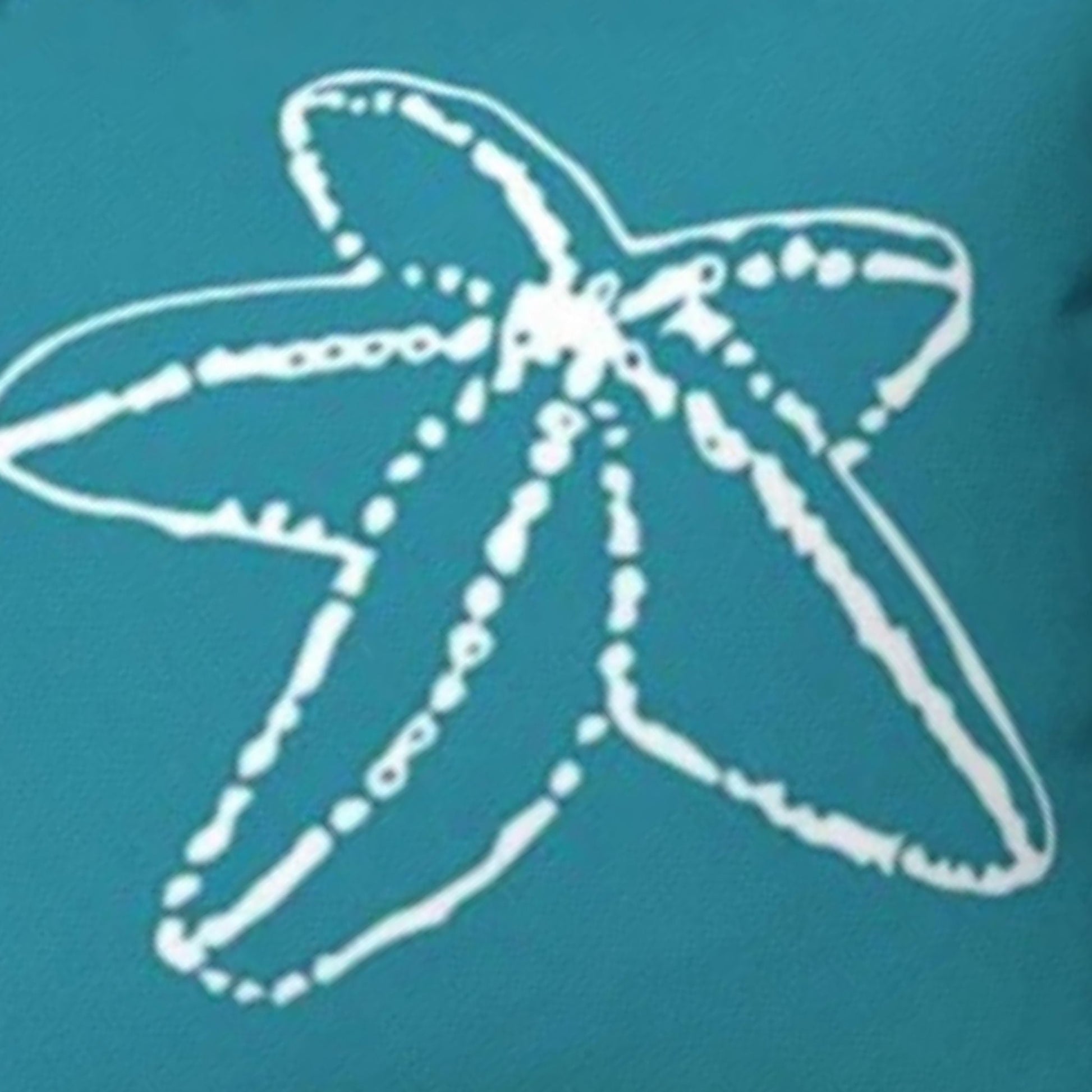 A close-up of a teal pillow with a white hand-drawn starfish outline graphic.