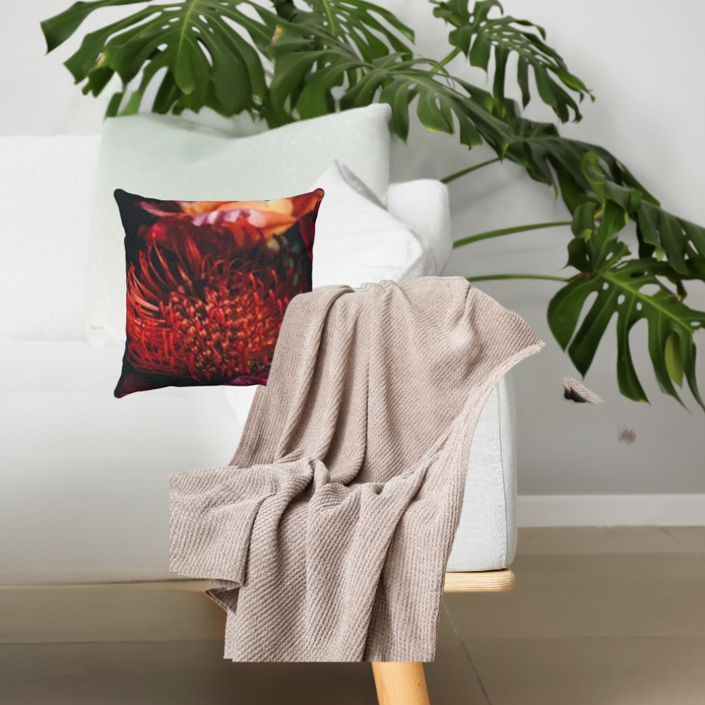 shown on a white couch with a grey blanket and a large plant
