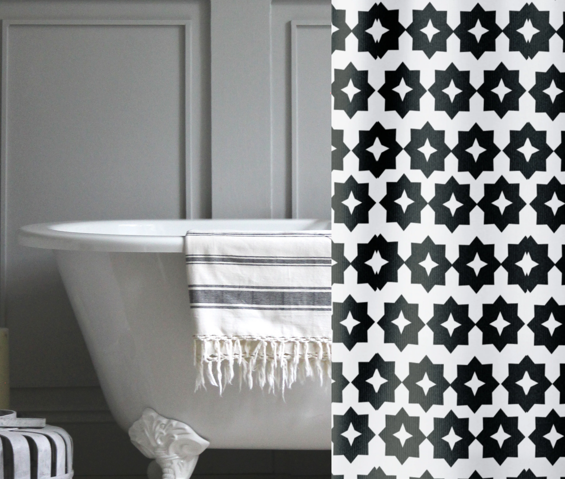 A black and white, crisp geometric shower curtain shown in a gray bathroom