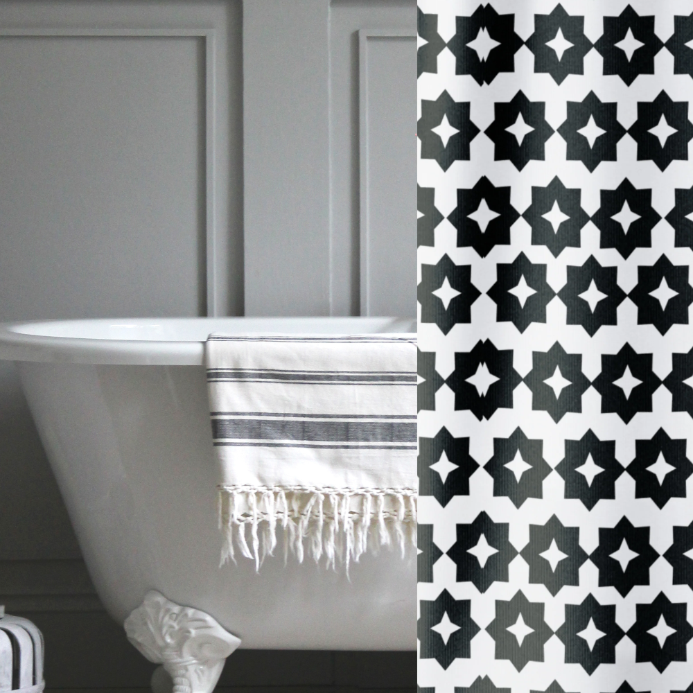 A black and white, crisp geometric shower curtain shown in a gray bathroom